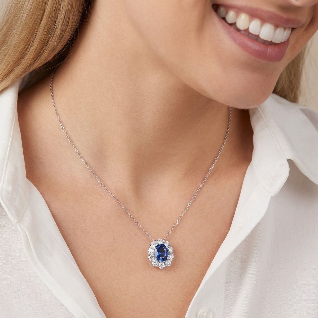 Lifestyle close-up of a model wearing a 0.8ct oval sapphire halo pendant necklace.