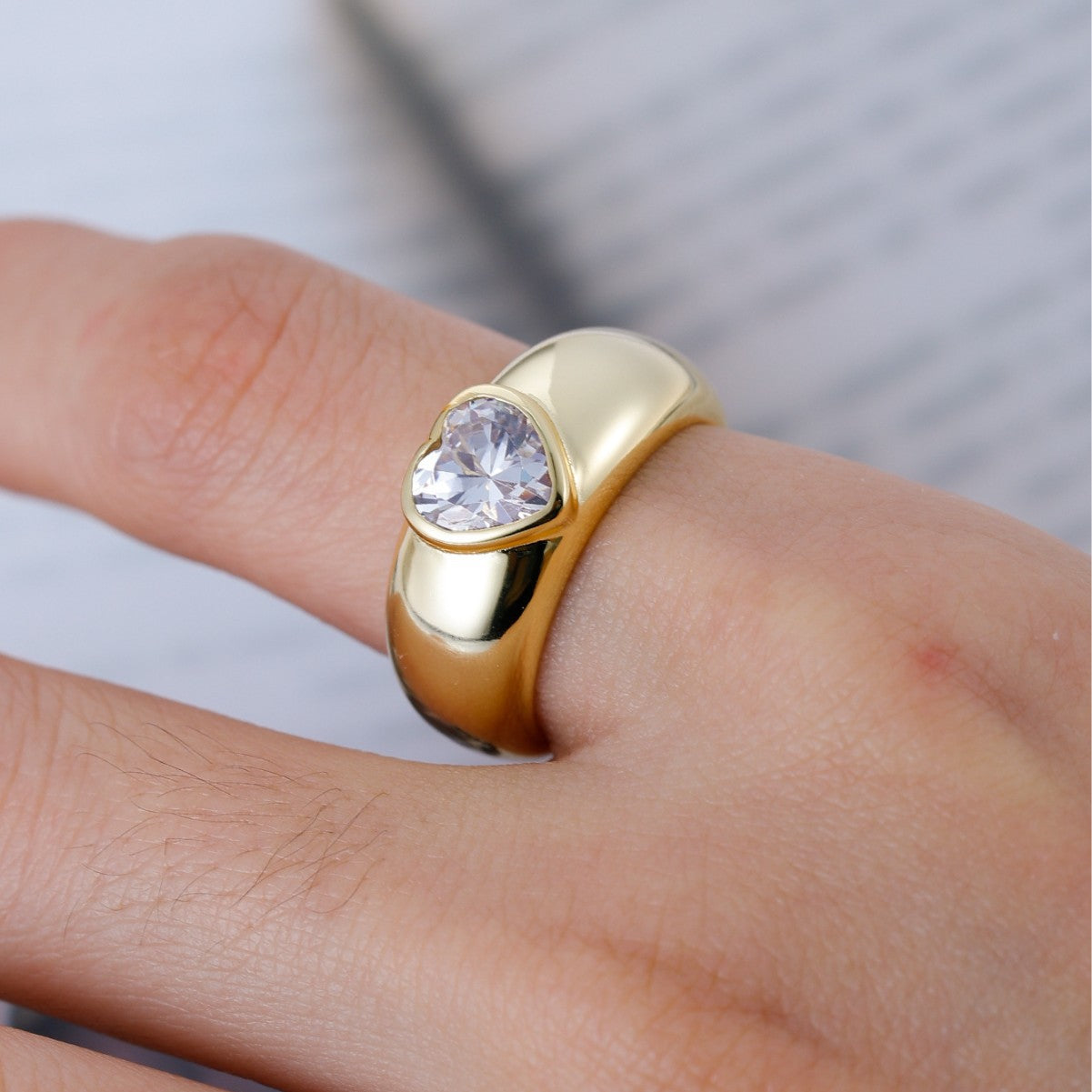Ring worn as romantic engagement or promise ring. Alt: “Heart Led: Moissanite Engagement Ring.”