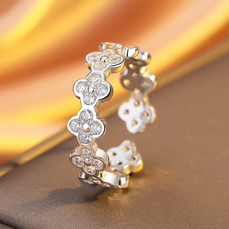 Pair of silver floral earrings on a reflective surface with a blurred background