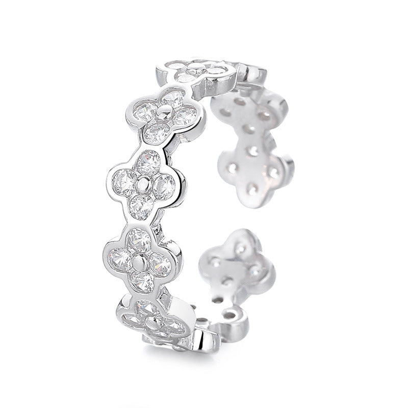 Silver floral earring with clear gemstones on a white background