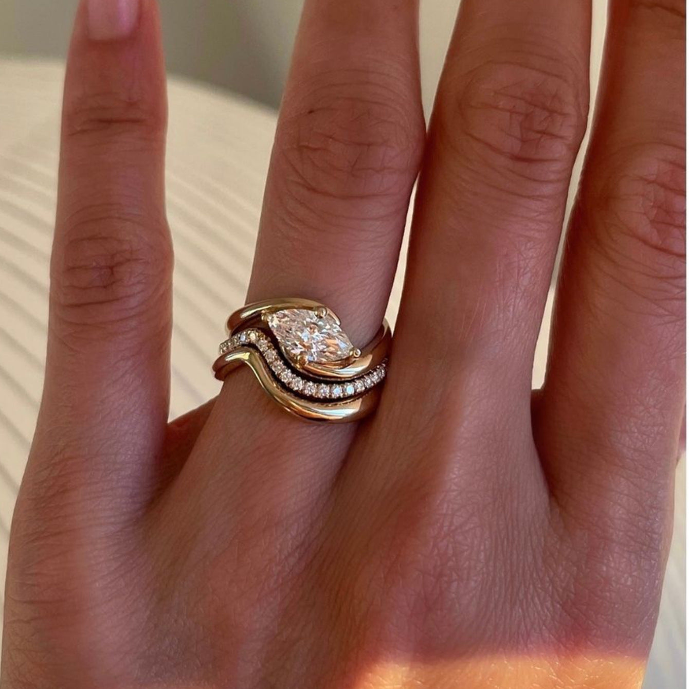 Set worn as triple-stacked wedding rings. Alt: “Layered Luxury: Marquise Diamond Triple Stack.”