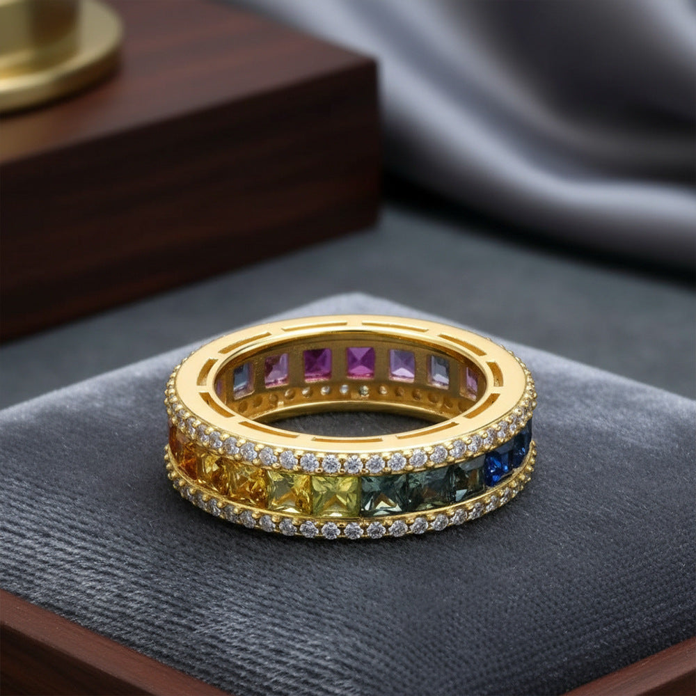 Gold 3mm princess cut rainbow channel-set eternity band ring displayed on velvet jewelry display cushion