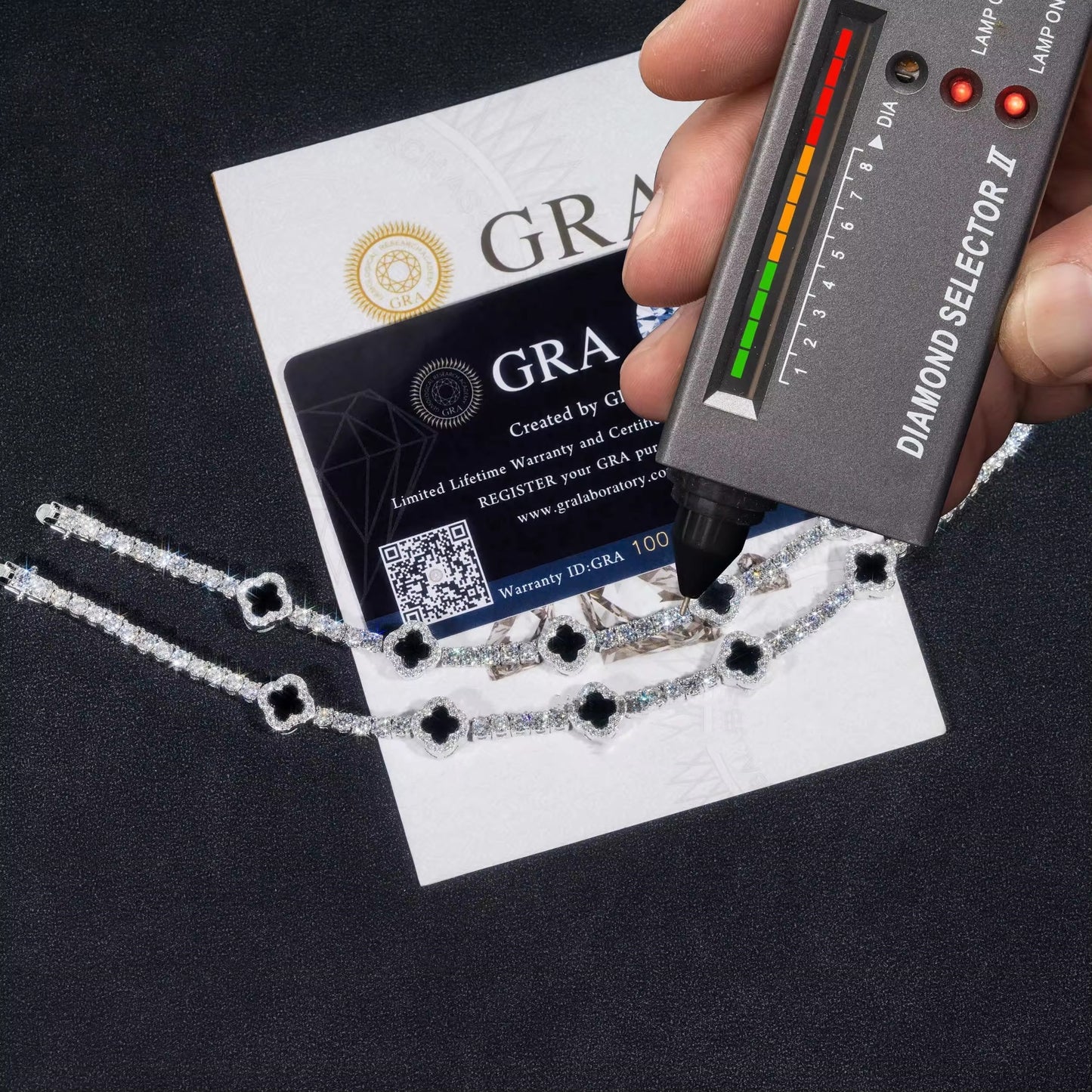 Diamond selector tool with a necklace and GRA certification card on a black background