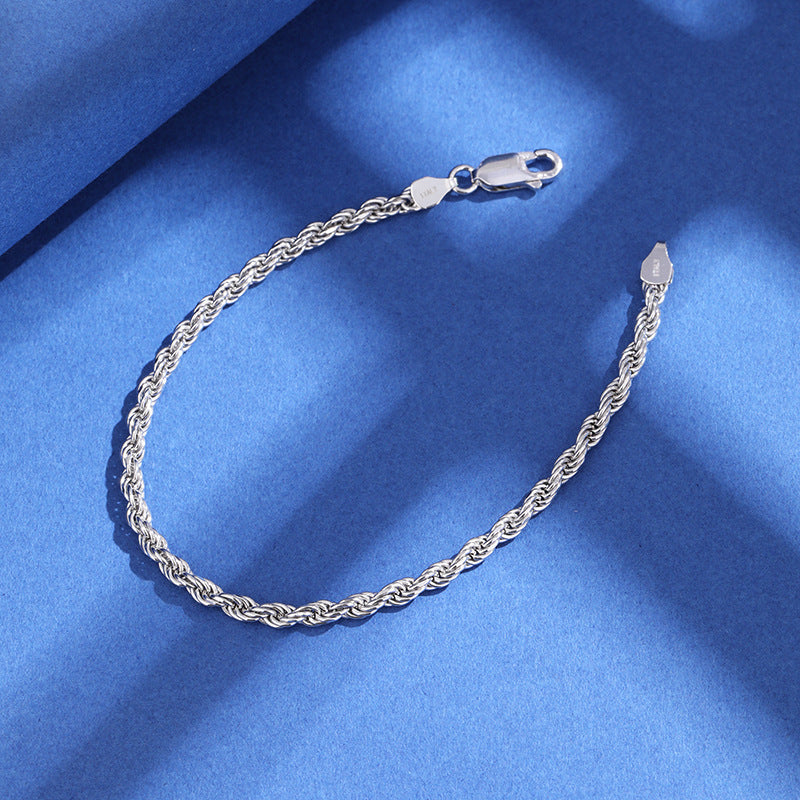 Silver chain bracelet on a blue fabric background