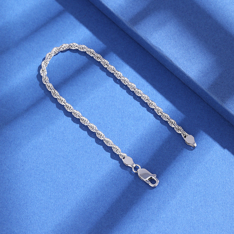 Silver chain bracelet on a blue fabric background