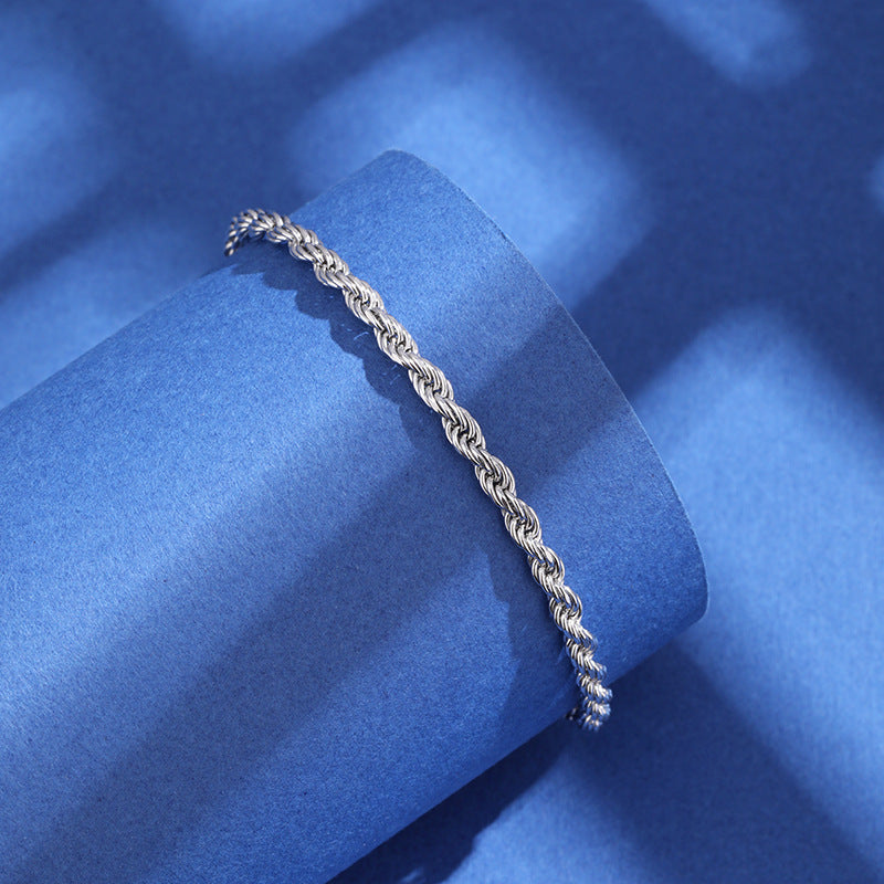 Silver chain bracelet on a blue textured surface