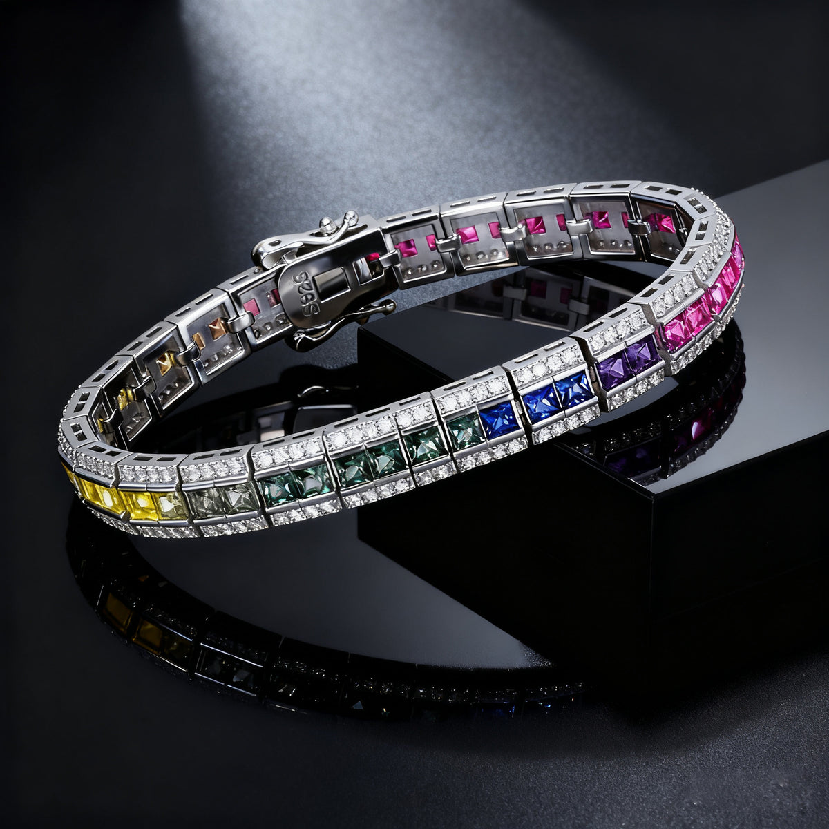 Silver 3x3mm princess cut rainbow channel-set tennis bracelet displayed on dark stone background