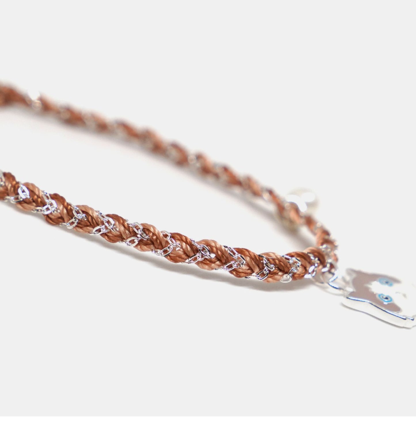 Brown braided bracelet with a silver clasp on a light background