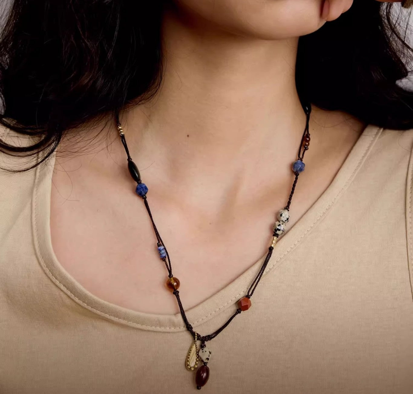 Necklace with beads worn by a person, close-up shot.