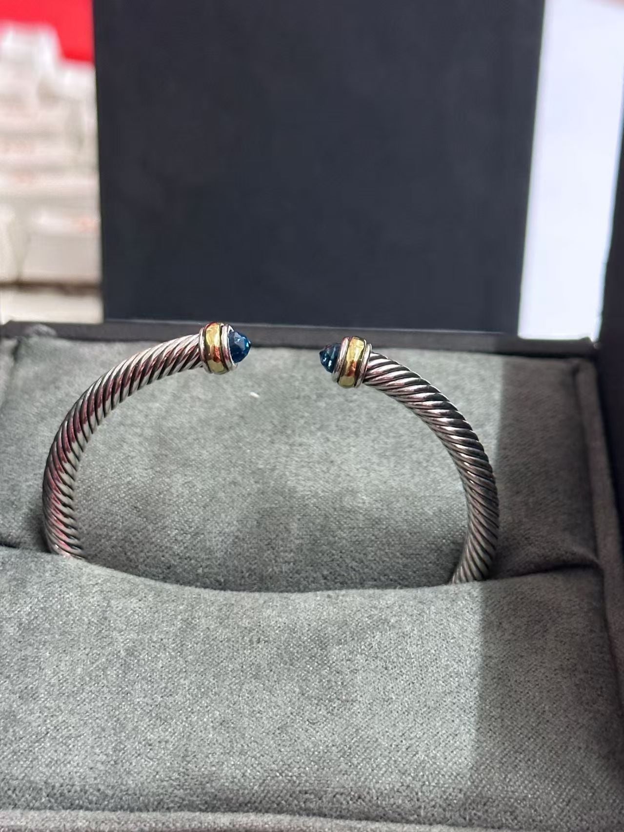 Silver bracelet with blue stones on a gray surface