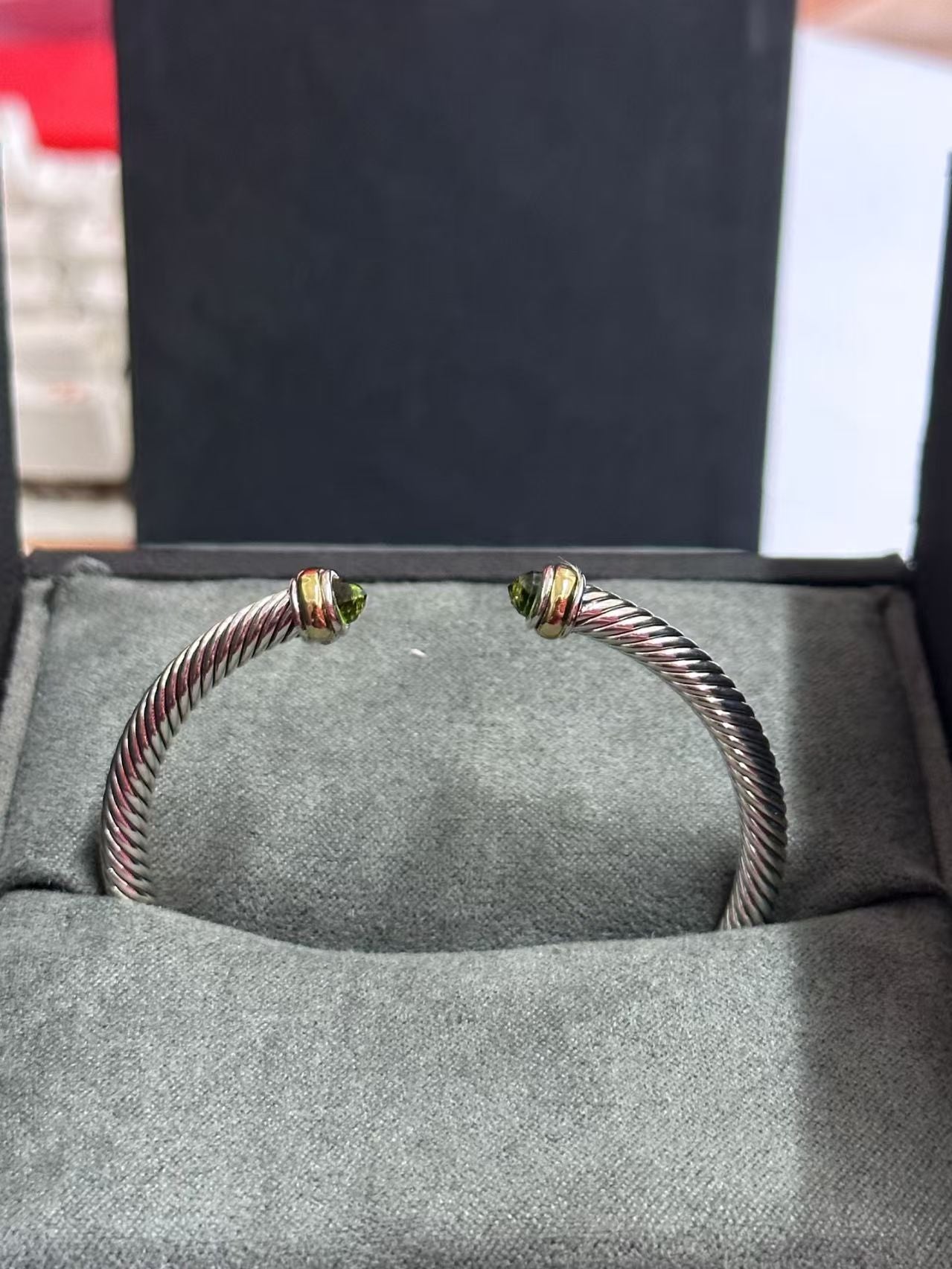 Silver bracelet with gold accents on a gray surface