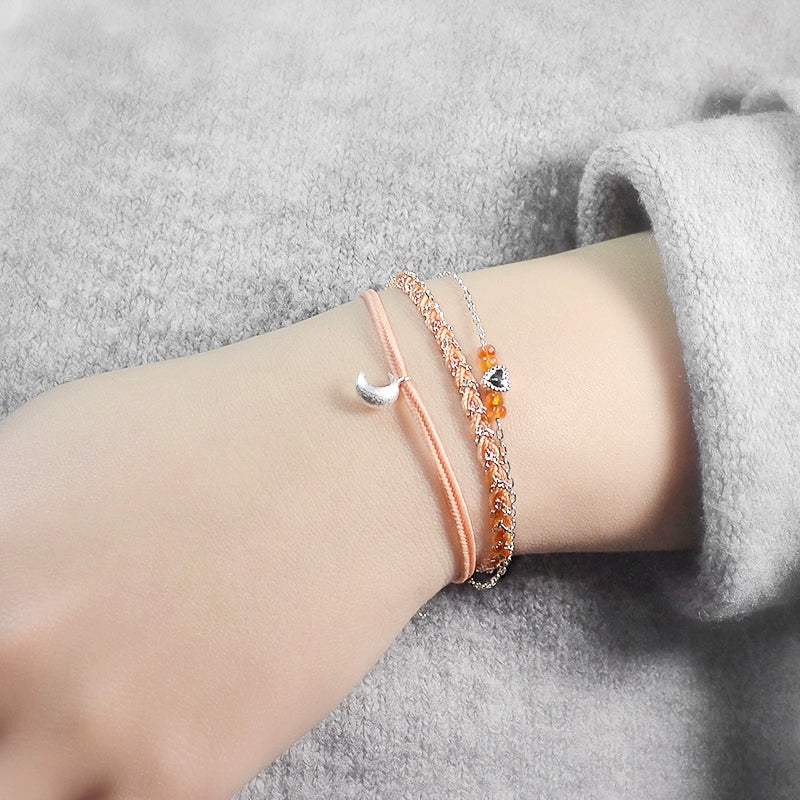 Close-up of a wrist wearing two bracelets on a gray surface