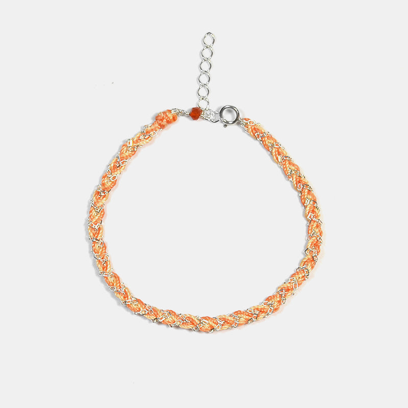 Bracelet with orange and silver braided design on a white background