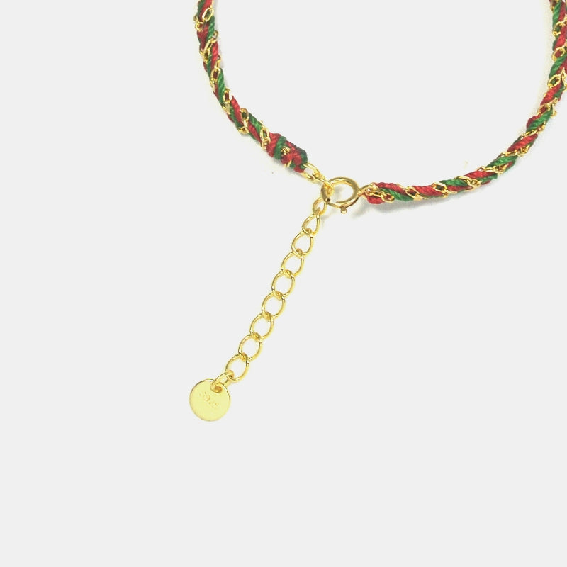 Bracelet with green and red braided cord and gold chain on a white background