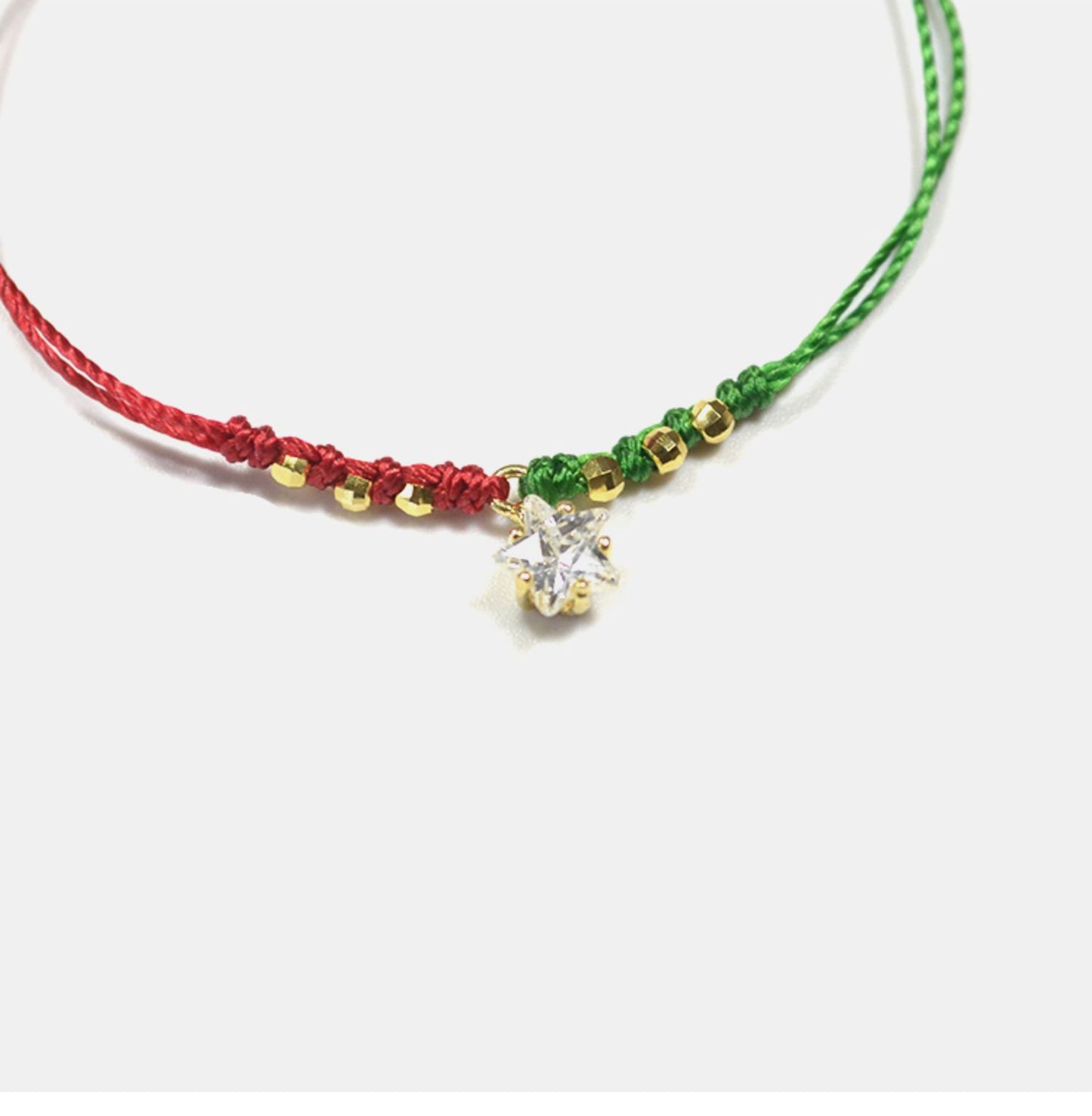 Necklace with red and green cord and gold accents on a white background