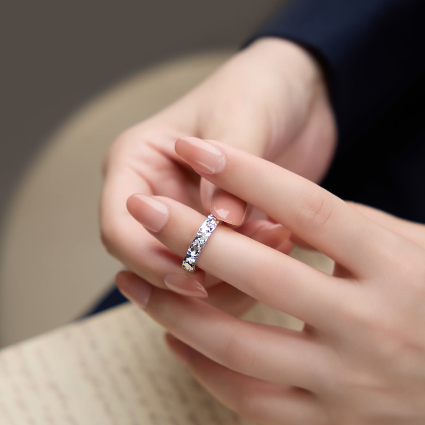 Close-up of a hand wearing a ring with a blurred background