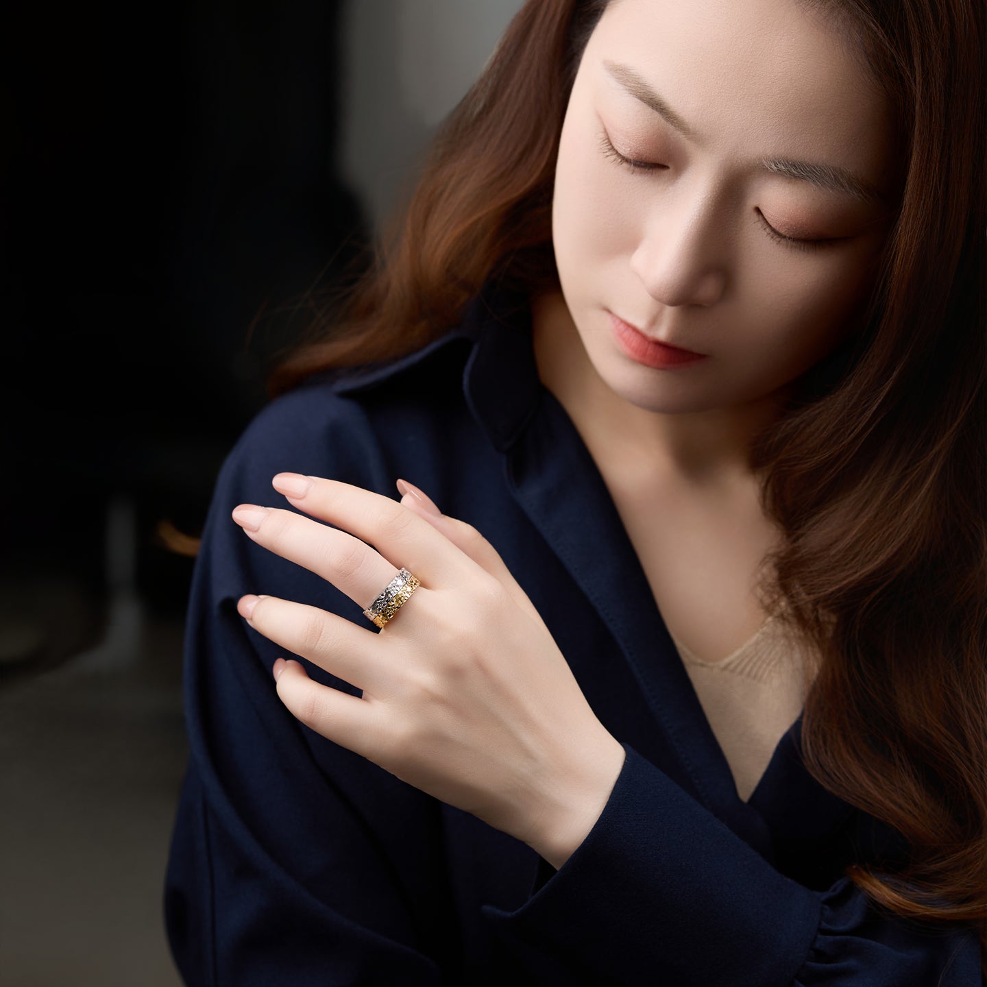Woman wearing a ring with a dark background