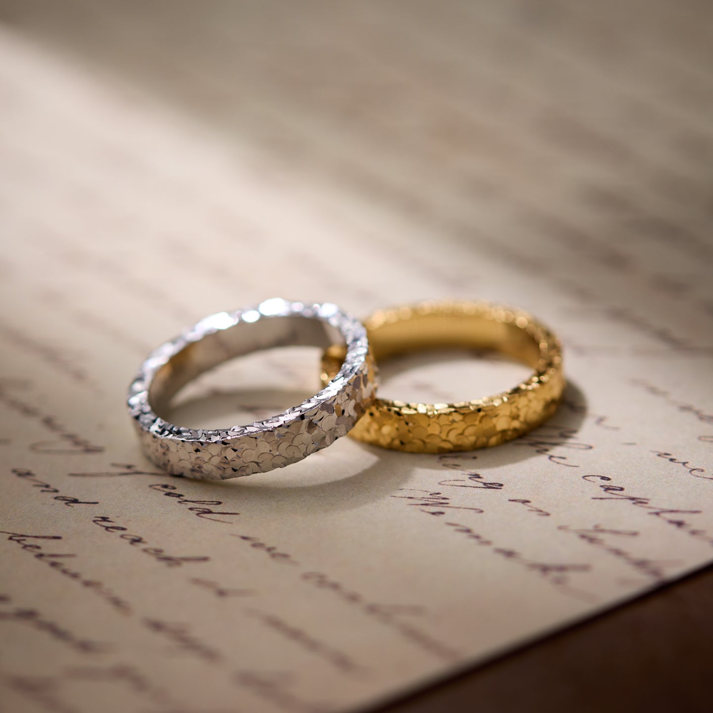 Two gold and silver rings on an old letter.