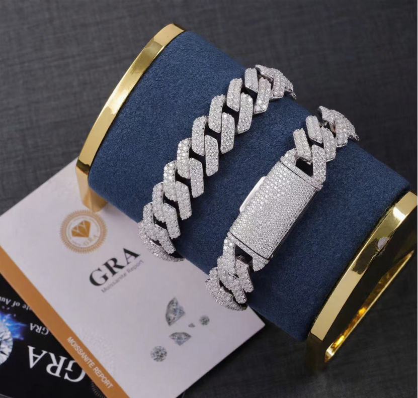 Silver bracelet with a gold clasp on a blue cushion, with GRA diamond report card in the background.