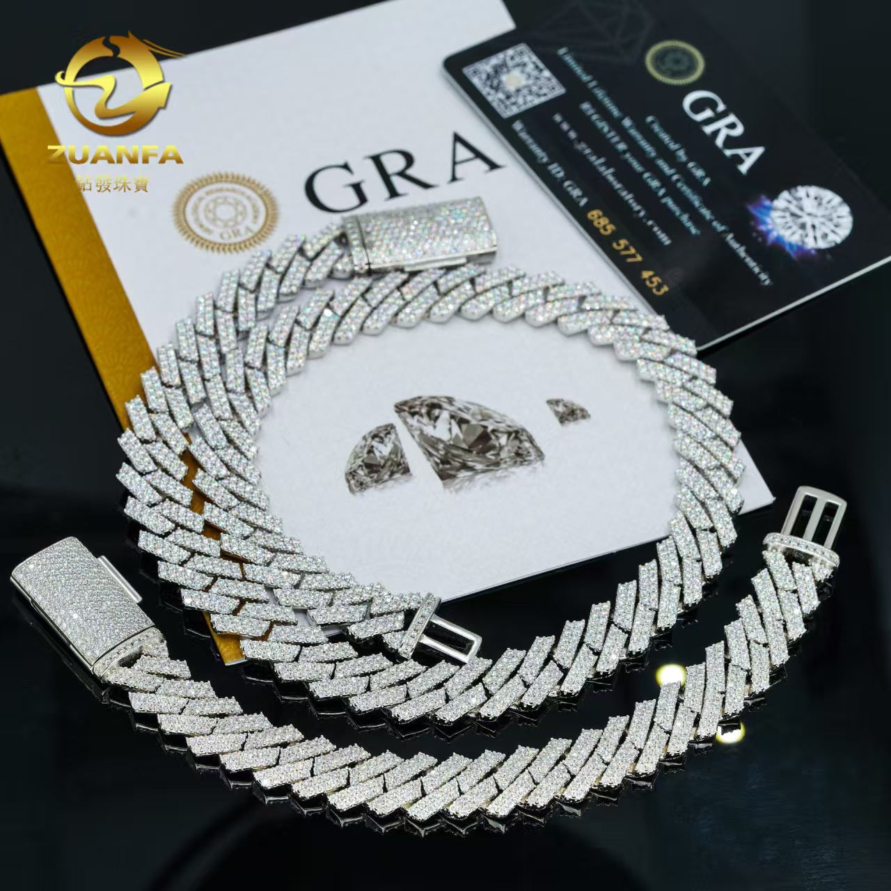 Silver chain necklace with diamond-like stones on a black background with branding visible.