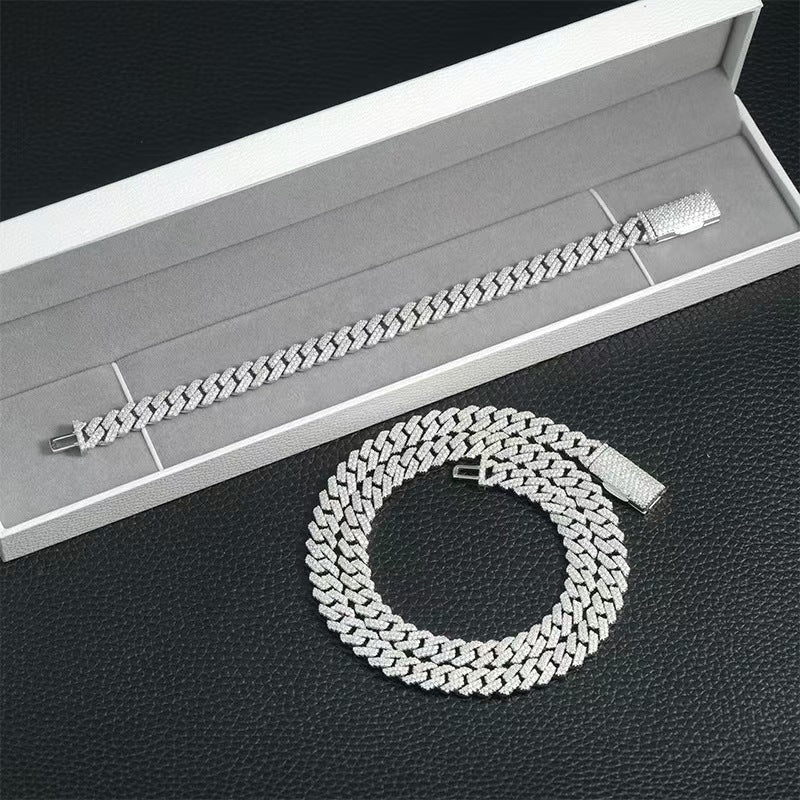 Silver chain bracelet on a textured surface with an open box in the background