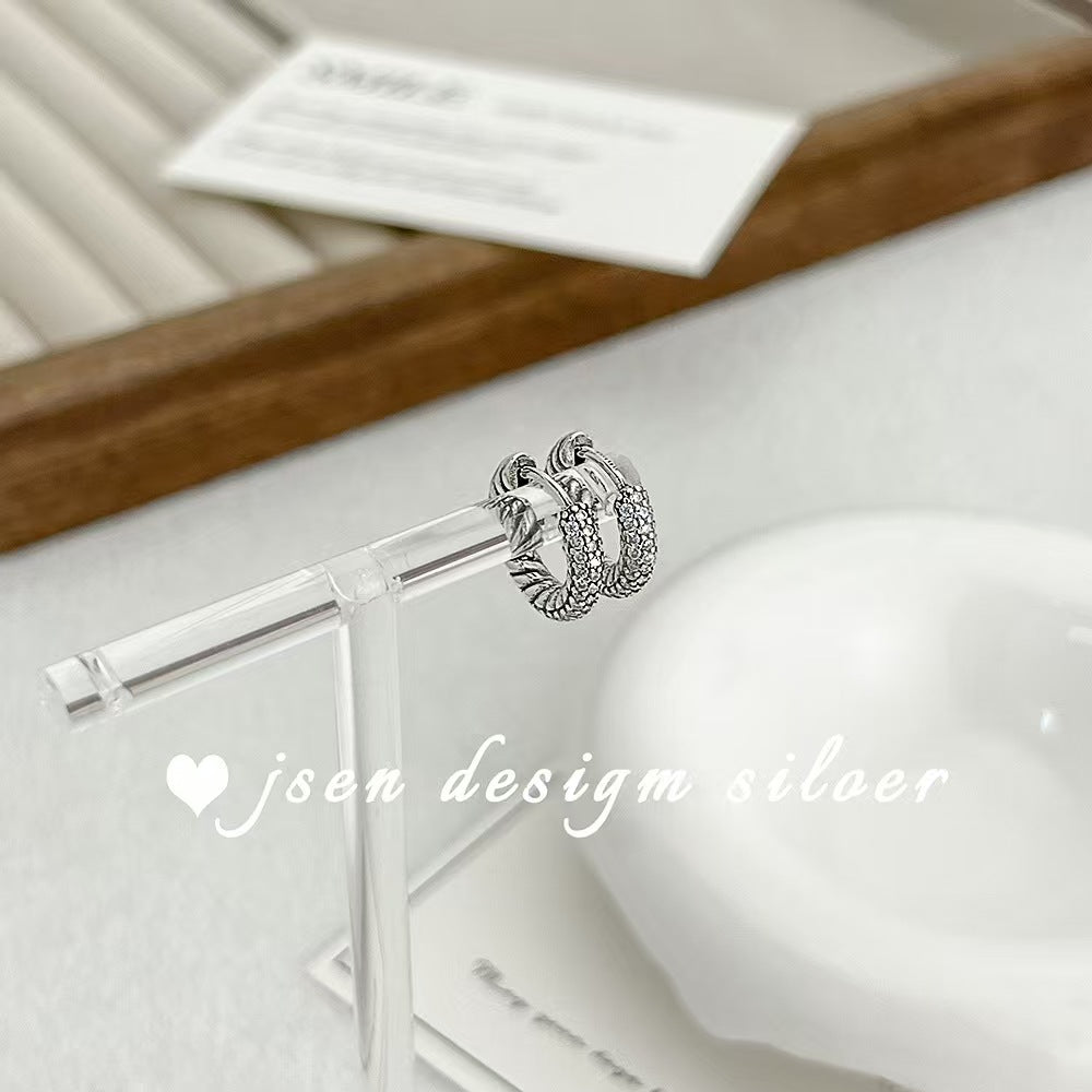 Silver hoop earrings on a clear stand with 'jsen design silver' branding.