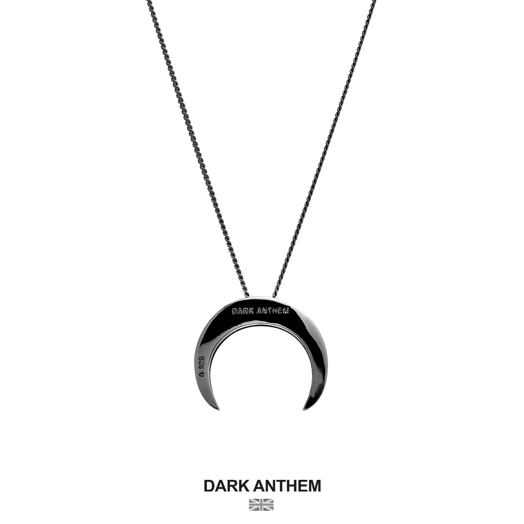 Crescent moon-shaped pendant necklace with 'Dark Anthem' branding on a white background