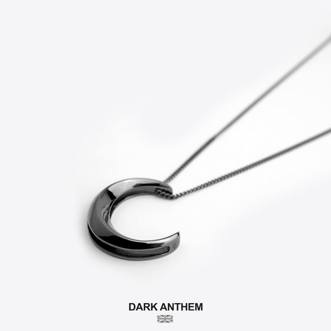 Crescent moon necklace on a white background with 'Dark Anthem' branding.