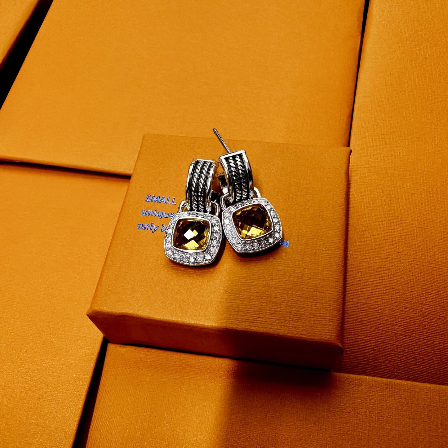 Pair of earrings on an orange box with a blurred background