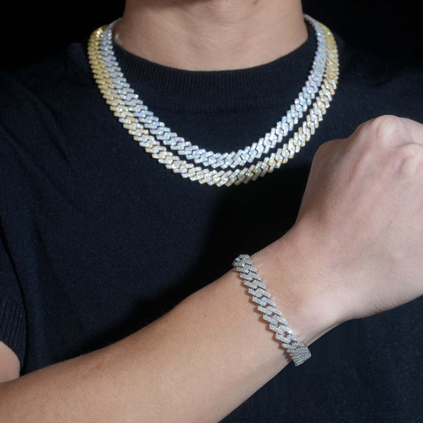 Person wearing a stack of diamond necklaces and a bracelet on a dark background