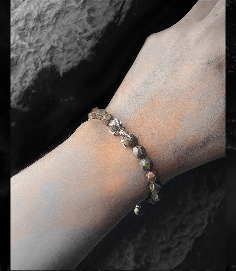 Bracelet with beaded design on a wrist against a dark background