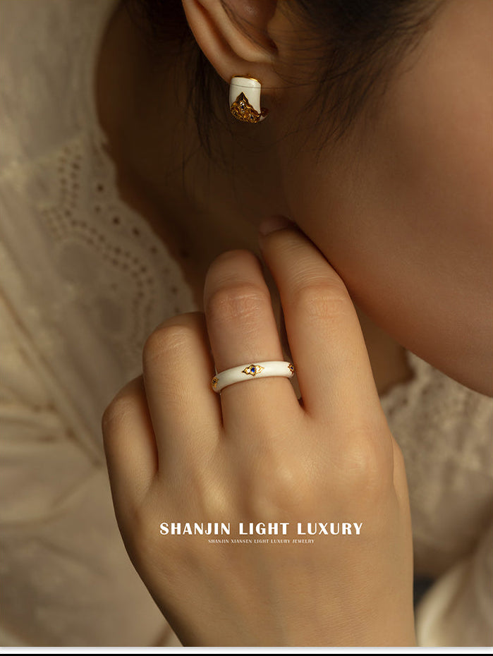 Close-up of a hand wearing a ring with an earring, featuring 'SHANJIN LIGHT LUXURY' branding.