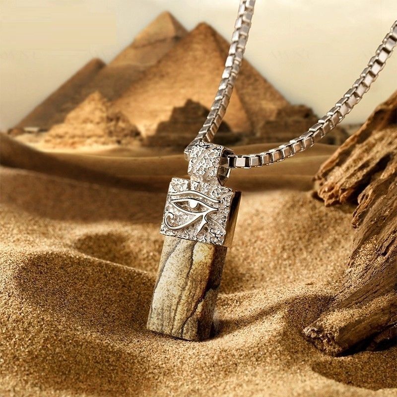Necklace with a pendant featuring an eye design, set against a desert background with pyramids.