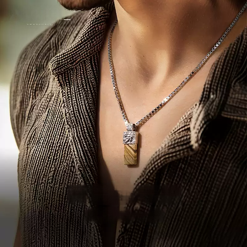 Close-up of a person wearing a necklace with a pendant, focusing on the jewelry.