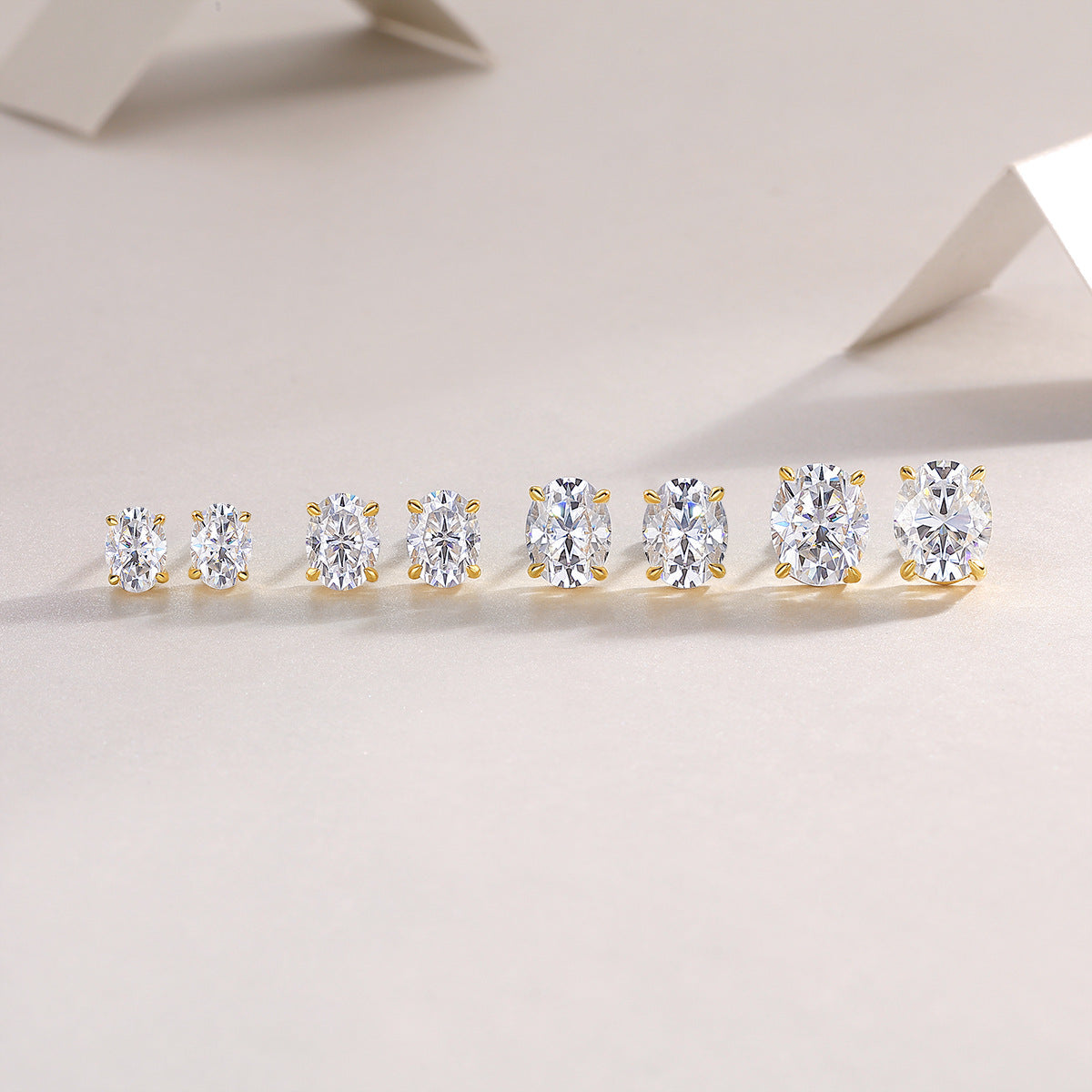 Gold oval moissanite studs on neutral or elegant background. Alt: “Four-Prong Oval Moissanite Stud Earrings – 18K Gold Plated Sterling Silver.”