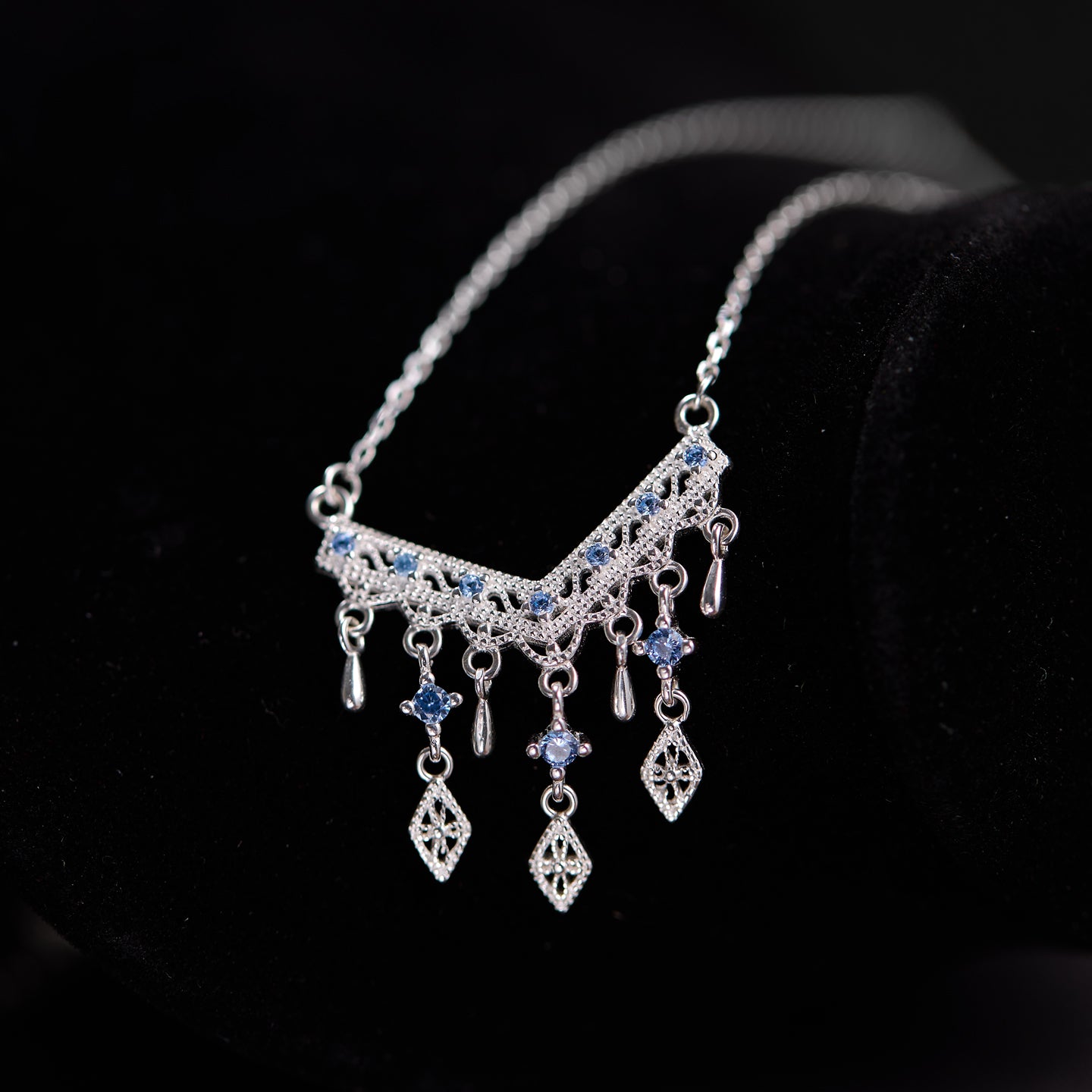 Silver necklace with blue stones on a black background