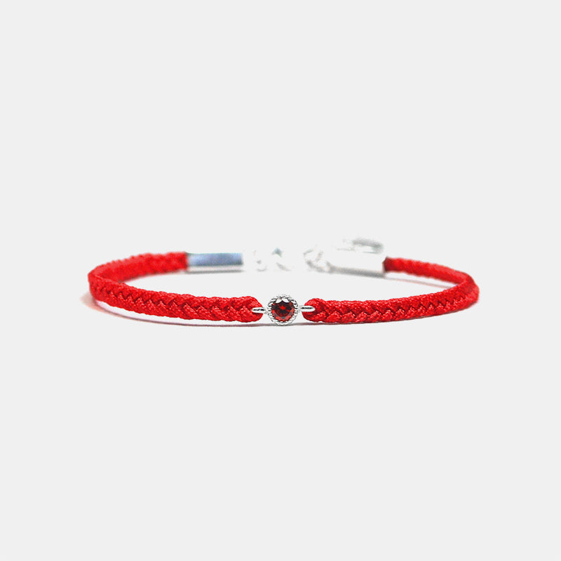 Red braided bracelet with a silver clasp on a white background
