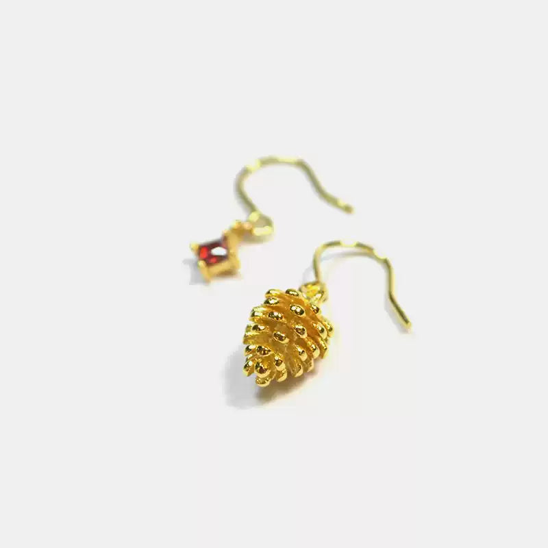 Gold pineapple-shaped earrings on a white background