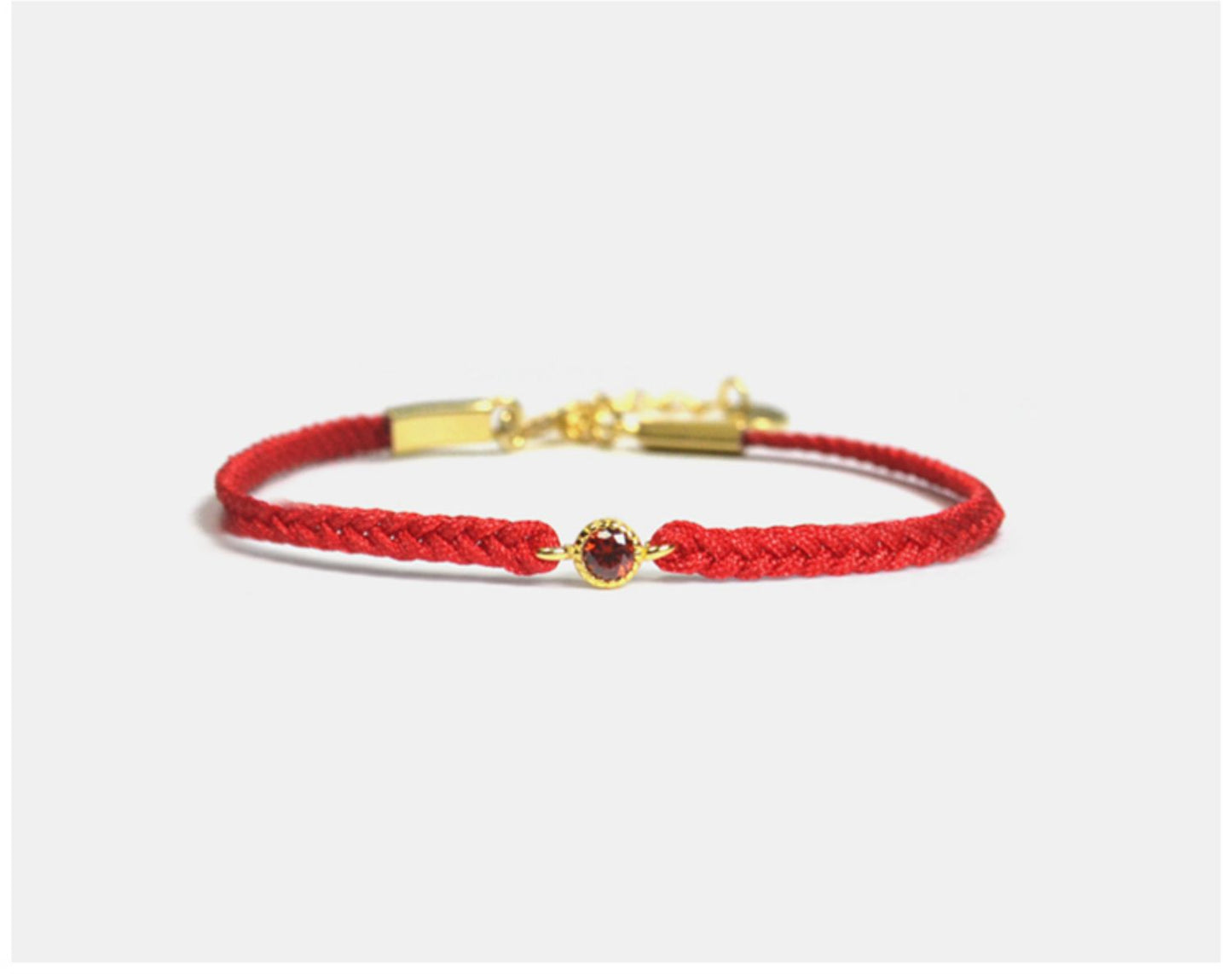 Red bracelet with a gold clasp on a white background