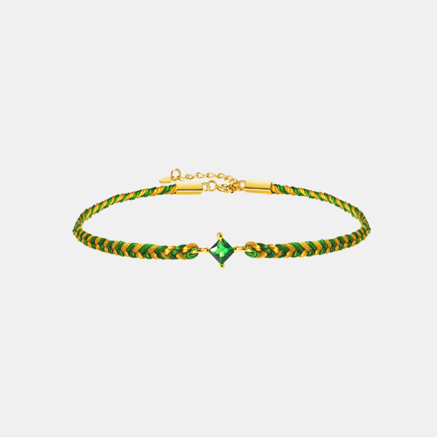 Green and gold bracelet with a central gemstone on a light gray background