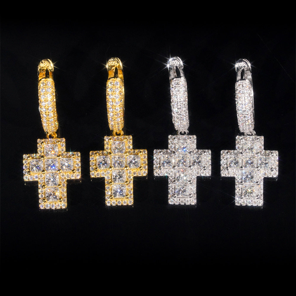 Pair of gold hoop earrings with cross designs on a black background