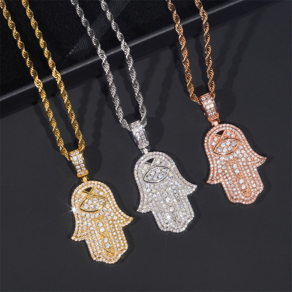 Three Hamsa hand pendants on chains in gold, silver, and rose gold on a dark background.