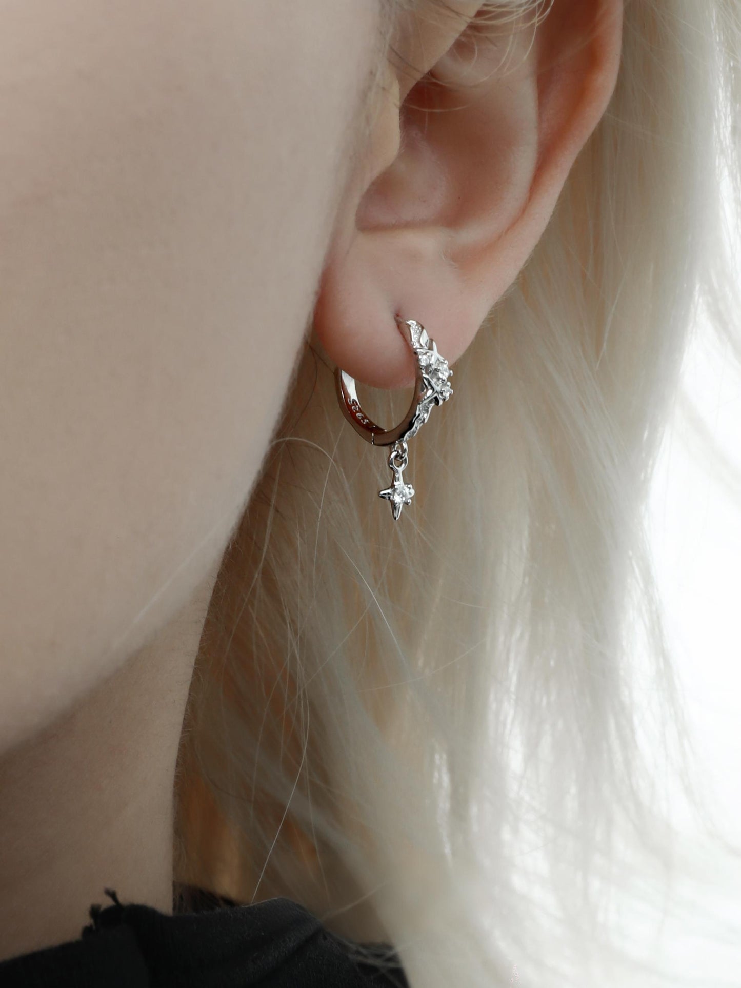 "Unisex model wearing sleep-in piercing-friendly silver huggie earrings"