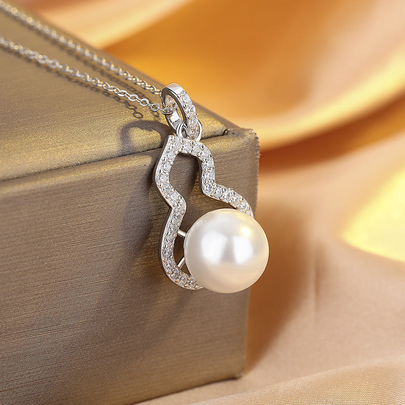 Pearl necklace with silver pendant on a beige fabric background