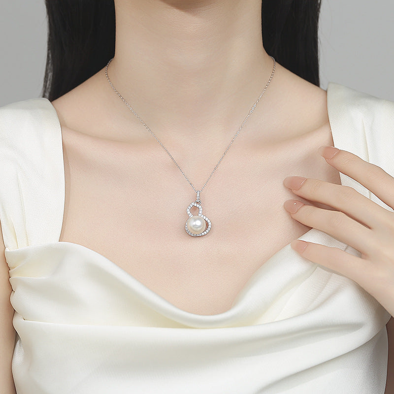 Pearl necklace with silver pendant on a model wearing a white top