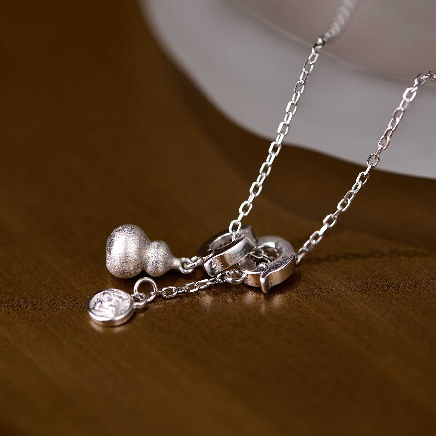Silver necklace with charms on a wooden surface