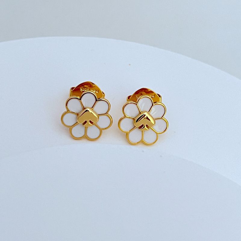 Earrings on a soft linen or kraft paper background, evoking vintage luggage tags and travel ephemera. Alt: “Kate Spade Day Tripper Earrings – Travel-Themed Enamel Charm Jewelry.”