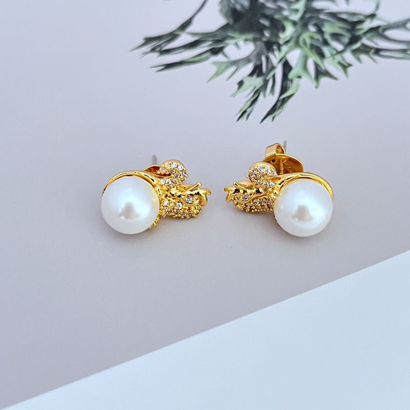 Earrings on deep jewel-tone background. Alt: “Kate Spade Dazzling Dragon Stud Earrings – Enamel Mythical Jewelry.”