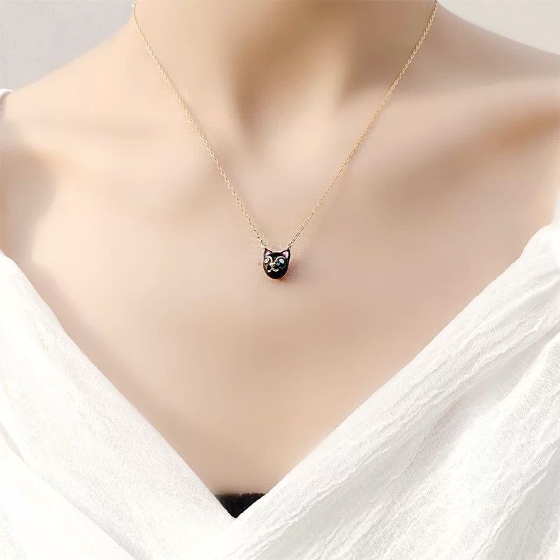 Necklace worn with a casual tee or sweater, showcasing its subtle, daily-wear appeal. Alt: “Everyday Whimsy: Kate Spade Cat Pendant Necklace Styled Casually.”