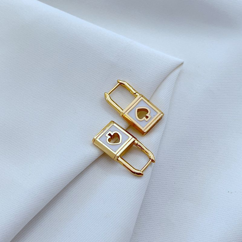 Earrings on a soft black or charcoal background, showcasing the gold spade and padlock charms with black enamel details. Alt: “Kate Spade Lock & Spade Earrings Black & Gold – Signature Enamel Drop Jewelry.”